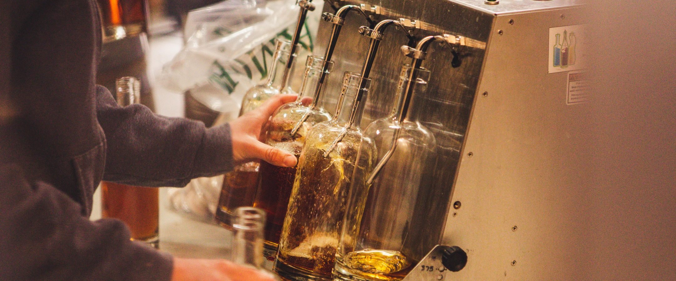 Person distilling liquor into bottles