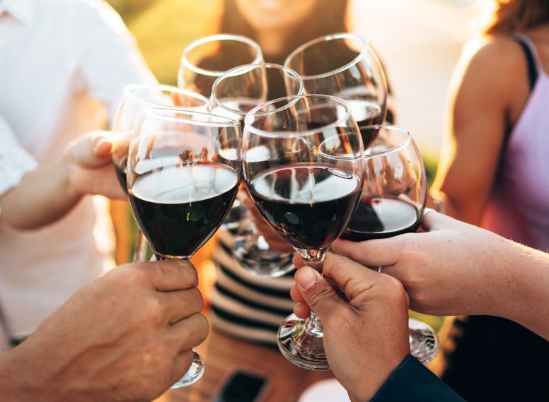 Friends toasting with red wine in wine glasses