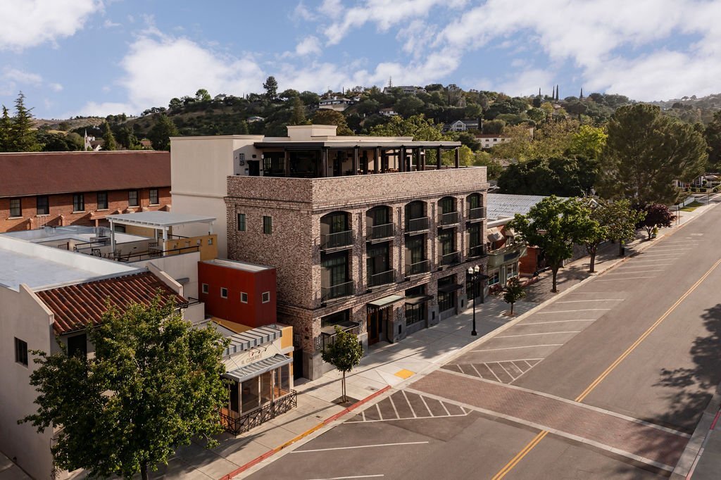 An aerial view of a brick building along an empty street