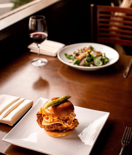 A picture of a fried chicken sandwich  and a salad on a table