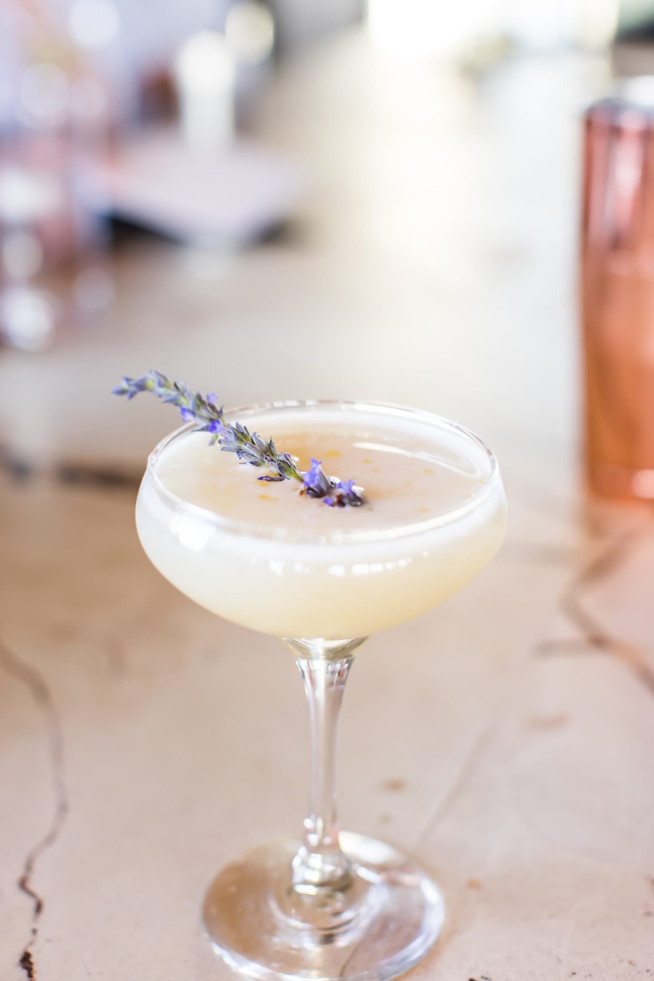 A close up of a cocktail wit lavender garnish