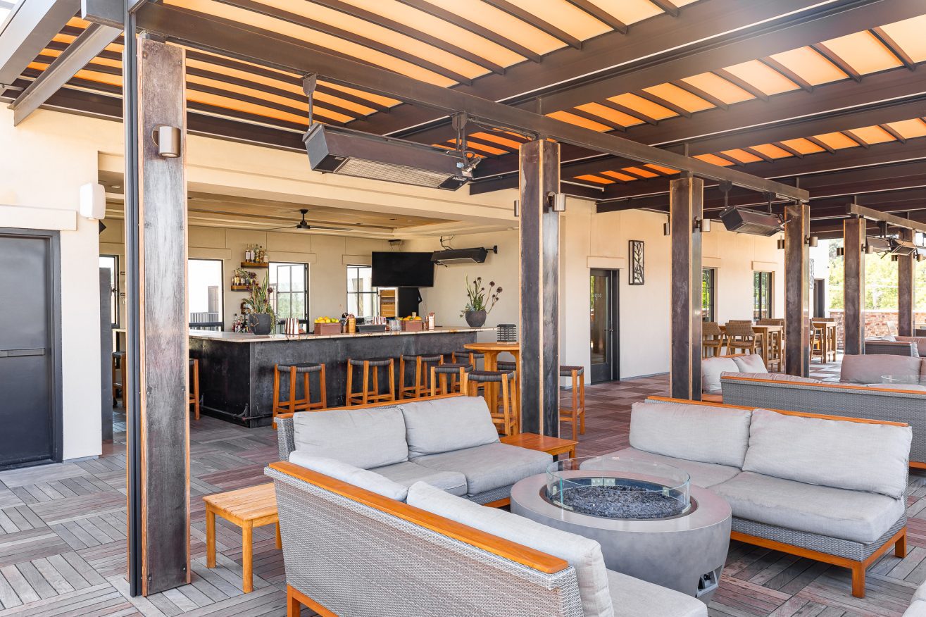 A rooftop bar with comfortable sofas around a fire pit